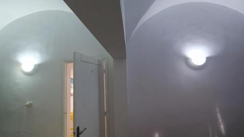 two lights on the wall of a bathroom with a mirror at Maison Sérénité Campagne in Hammamet Sud