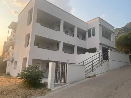 a white building with a gate in front of it at Stan Bijela Kuca in Sutomore