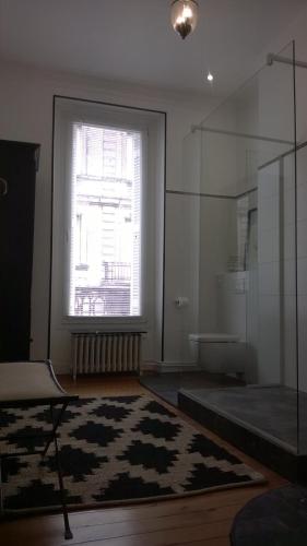 - un salon avec une grande fenêtre et un tapis dans l'établissement MAISON D'HÔTES 