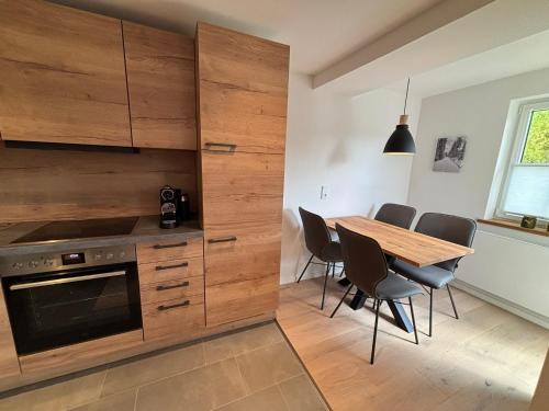 a kitchen with a table and a wooden wall at Fichtellofts in Bischofsgrün