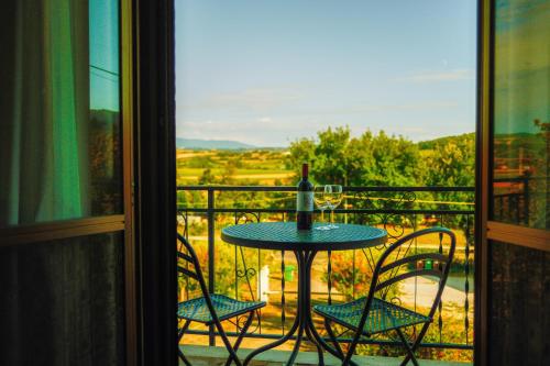 a table with a wine bottle and two chairs on a balcony at Cozy Room with Balcony, Ping Pong & Billiard Table in Monte Molino