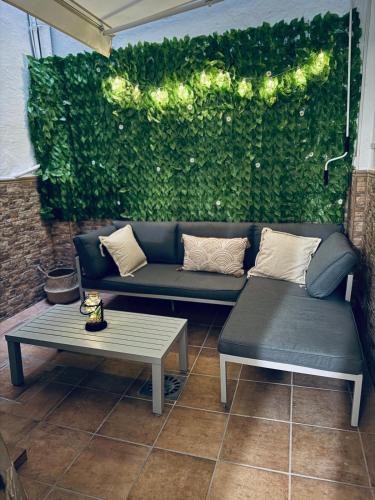 a couch and a table in front of a green wall at Apartamento Jumar Costa del Sol in Torre del Mar
