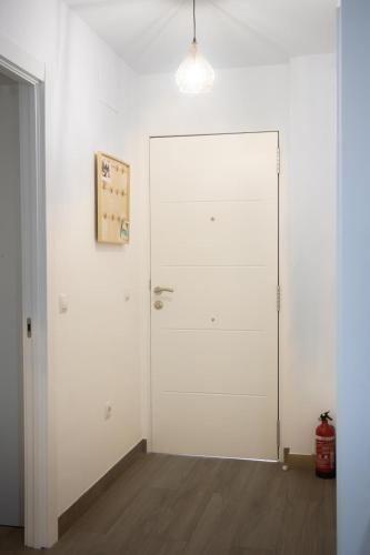 a white door in a room with a wooden floor at Apartamento Jumar Costa del Sol in Torre del Mar