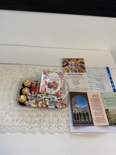 a magazine with a tray of donuts and a plate of food at צימר פסטורלי בהגושרים in Hagoshrim