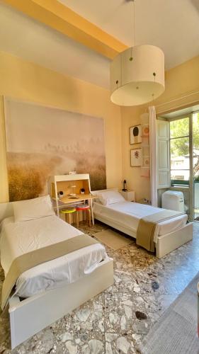 a bedroom with two beds and a painting on the wall at Three Rooms in Messina