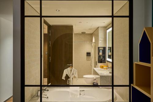 a bathroom with a tub and a toilet and a sink at Grand Park City Hall in Singapore