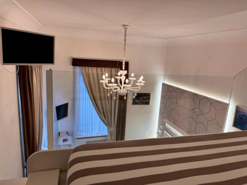 a bedroom with a bed and a chandelier at Le Suite del Duomo in Cava deʼ Tirreni