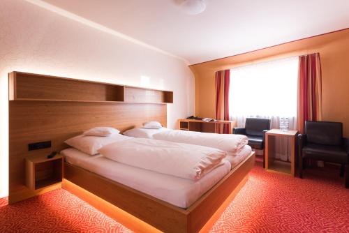 Cette chambre comprend deux lits et une grande fenêtre. dans l'établissement Bürgerbräu, à Überlingen