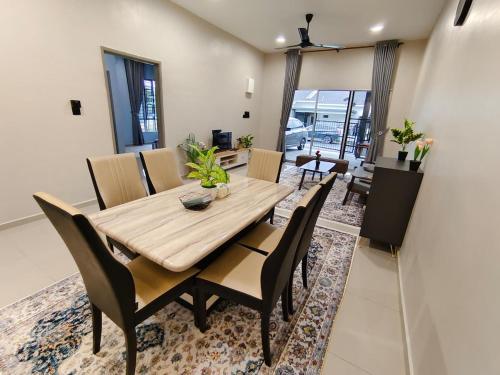 テメルローにあるSsri Homestay Temerlohの木製のテーブルと椅子のあるダイニングルーム