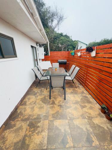 a patio with a table and chairs and a fence at Lindo Departamento Con Terraza y Parrilla in Concón