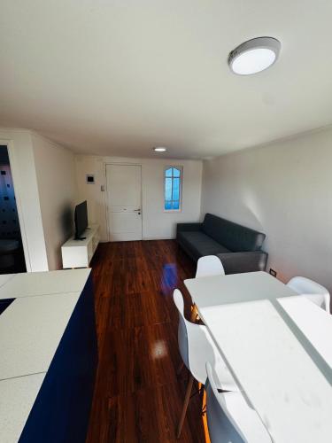 a living room with a couch and a tv at Lindo Departamento Con Terraza y Parrilla in Concón