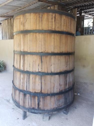 a large wooden barrel sitting under a building at Chales rota da pedra in São Bento do Sapucaí