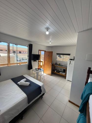 a bedroom with a large bed and a kitchen at Morada Silveira in Pinheiro