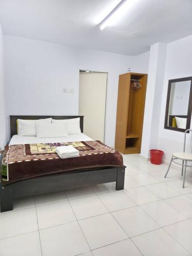 a bedroom with a bed and a table and a chair at Zahaar KN Inn in Batu Ferringhi