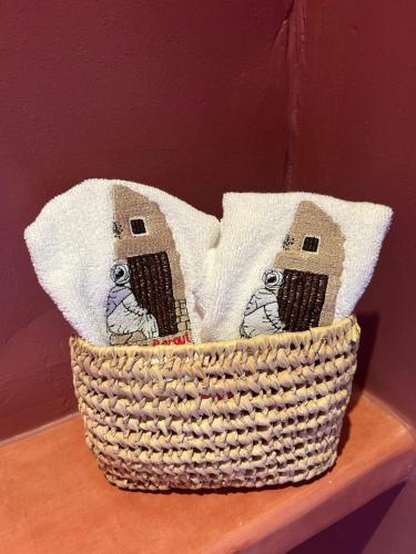 a basket with two pillows on a wooden shelf at Riad Dar Bergui in Ouarzazate