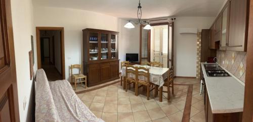 Una cocina y un comedor con mesa y sillas. en Appartamento " Il tramonto ", en Badesi