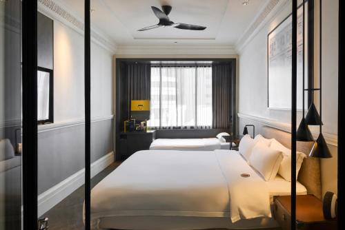 a bedroom with two beds and a ceiling fan at Grand Park City Hall in Singapore
