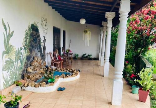 a house with a water fountain in the middle of a porch at Ameeila Villa in Kandy