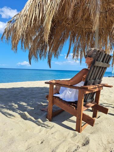 a person sitting in a chair under an umbrella on the beach at Bella Italia in Marina di Strongoli
