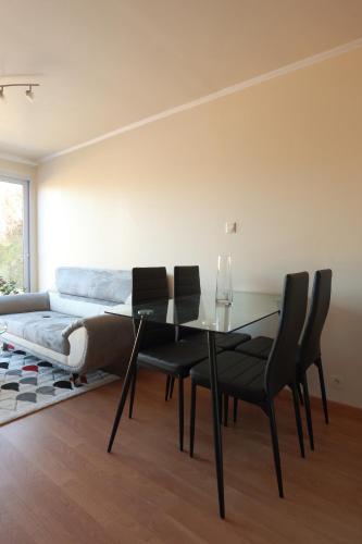 a dining room with a glass table and black chairs at les Tours de Bombel in Saint-Amand-de-Coly