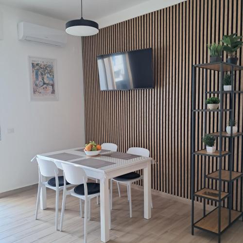 a dining room table with chairs and a television on a wall at Bella Italia in Marina di Strongoli