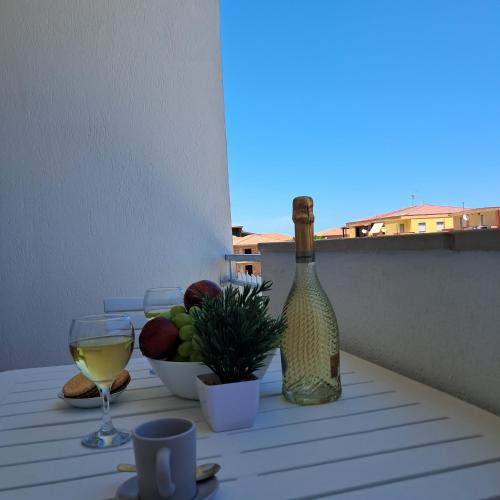 a bottle of wine and a bowl of fruit on a table at Bella Italia in Marina di Strongoli