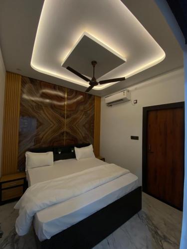 a bedroom with a large bed with a ceiling at Shree Premanand Dham Naimisharanya in Naimishāranya