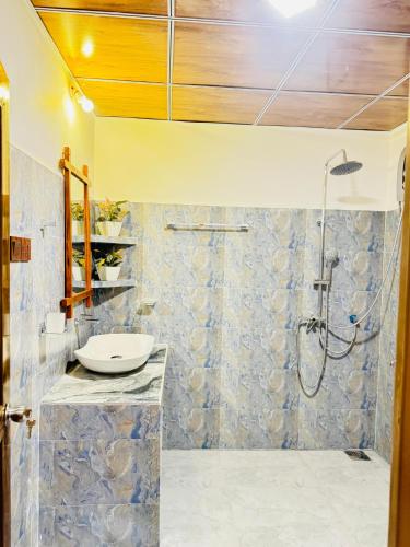 a bathroom with a sink and a shower at Sigiri Tarushan Home Stay in Sigiriya