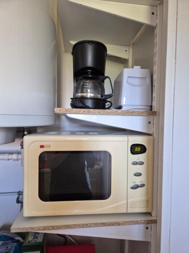 a microwave oven sitting on top of a shelf at L'ancre du Port in Saint-Quay-Portrieux