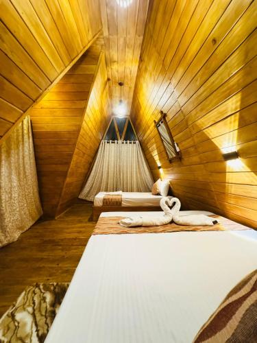 a bedroom with two beds in a wooden room at Sigiri Tarushan Home Stay in Sigiriya