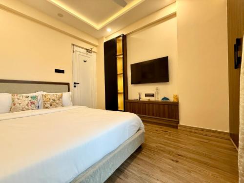 a bedroom with a bed and a flat screen tv at Cocoon By Ichamati in Thākurdwari