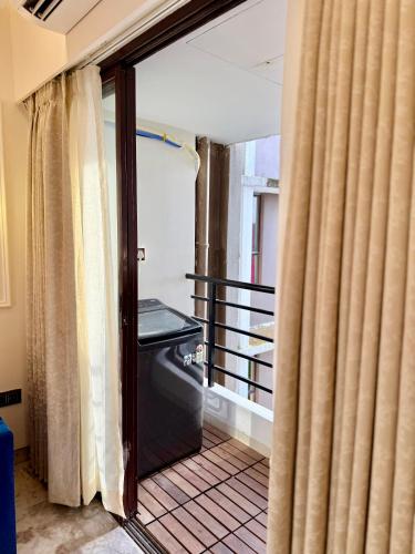 an open door to a balcony with a window at Cocoon By Ichamati in Thākurdwari
