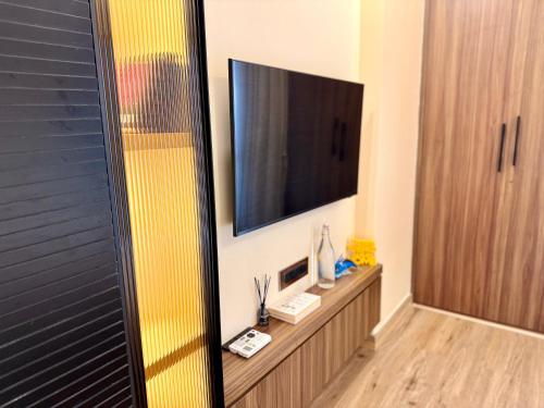 a bathroom with a television and a wooden cabinet at Cocoon By Ichamati in Thākurdwari