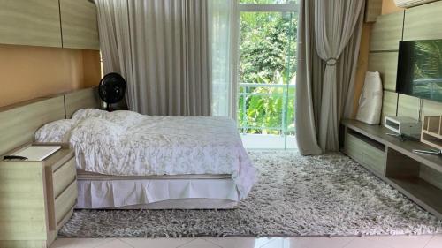 a bedroom with a bed and a large window at suite em condominio in Belém