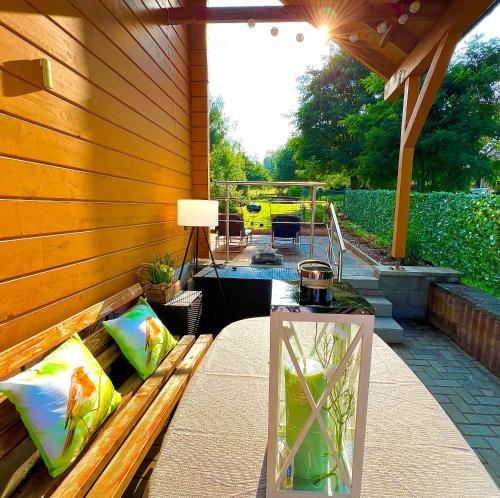 a patio with a wooden wall with a table and a lamp at Landhaus AUSZEIT in Borod
