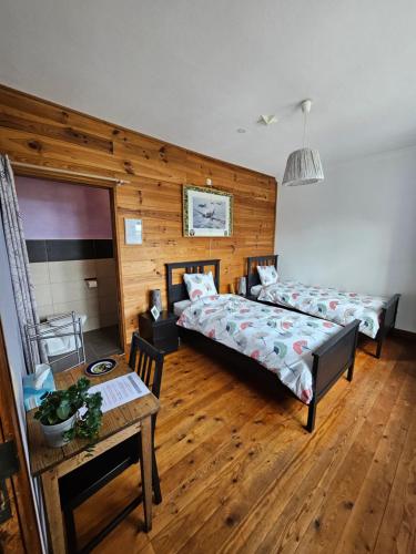 a hotel room with two beds and a table at Santa Fe - Lutrebois in Bastogne