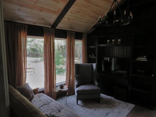a living room with a couch and a chair and a window at The River Cabin in Mauston