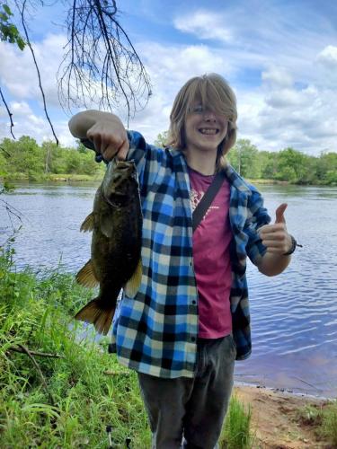a woman holding a fish in her hand at The River Cabin in Mauston