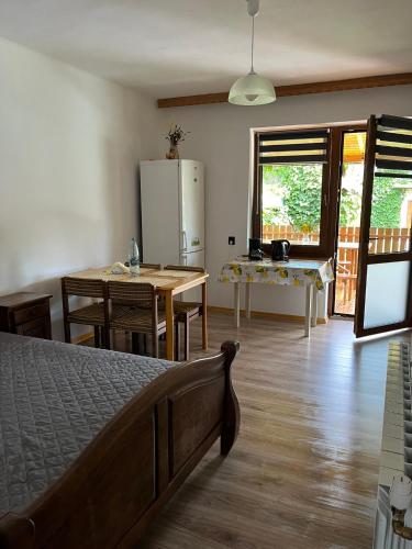 a bedroom with a bed and a table and a kitchen at Siedlisko pod Lasem in Józefów