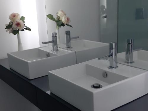 a white bathroom with two sinks and a mirror at Casa Vista Mar in Fuzeta