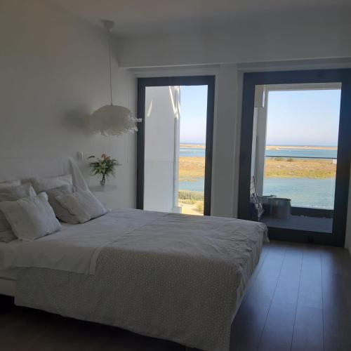 a bedroom with a bed with a view of the ocean at Casa Vista Mar in Fuzeta