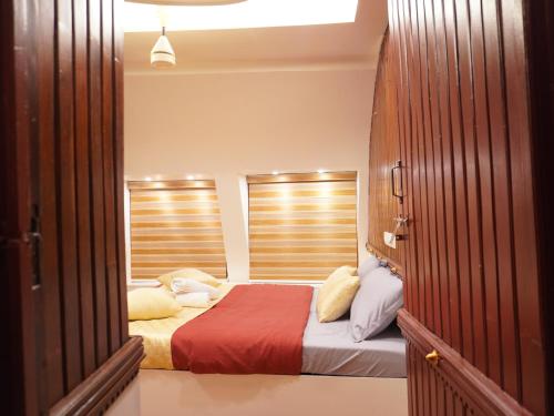 a bedroom with a bed with pillows on it at Alice Lake Promise in Alleppey