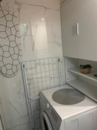 a bathroom with a washing machine in a white room at M&O Belgrade in Belgrade