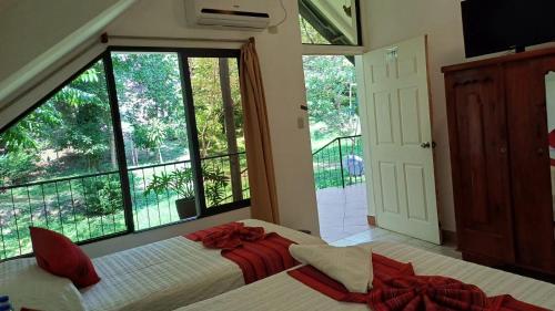 a bedroom with a bed and a large window at Hotel El Recreo Lanquín-Champey in Lanquín