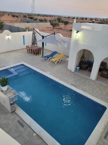a swimming pool in front of a villa at villa houch serine in Guellala
