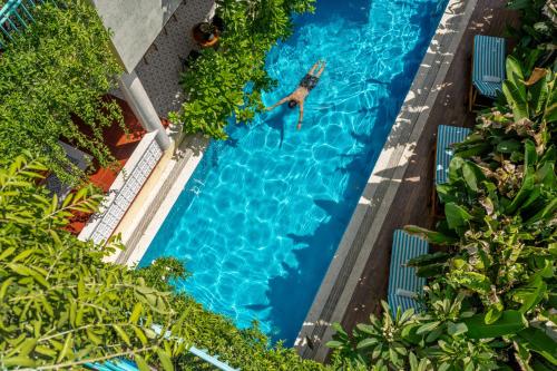 an overhead view of a man swimming in a swimming pool at Tropical An Bang Beach Villa in Hoi An