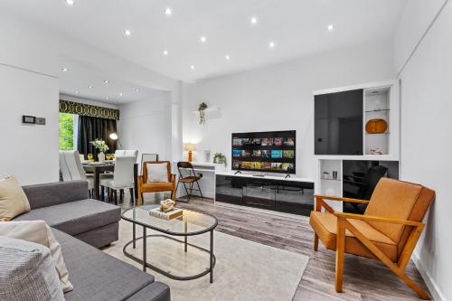 a living room with a couch and a table at Large Group StayI 5BR I Near Stadium & Tubes I Free Parking in London