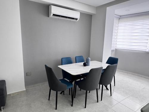 a dining room with a table and blue chairs at Hermoso Apartamento Mañongo - Hasta 6 personas in Naguanagua