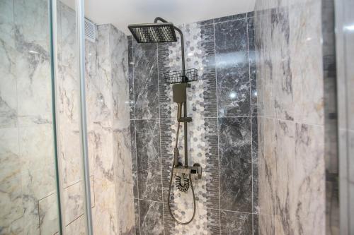 a bathroom with a shower with a glass door at Balkan Tower Deluxe Candy in Gabrovo