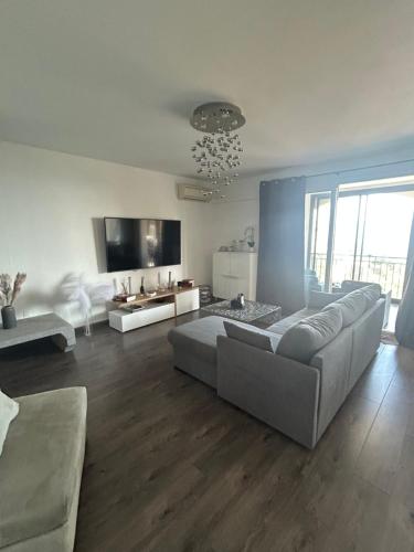 Una gran sala de estar con un sofá y un televisor. en Duplex F4-2 balcons face a la mer, en Ajaccio